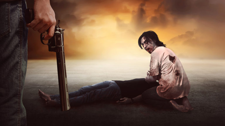 Brave man with jeans pants holding gun looking at zombie